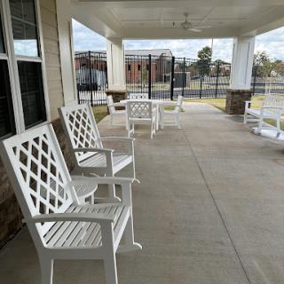 A serene outdoor porch featuring white chairs, perfect for relaxation.
