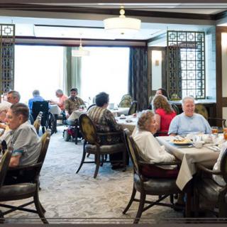 A bustling restaurant with patrons dining and socializing at various tables.