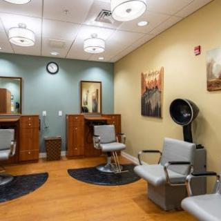 Interior of a modern barber shop with chairs and styling stations.