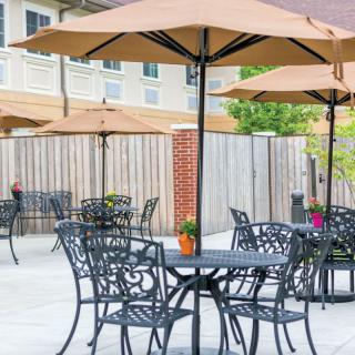 Outdoor patio area with tables, chairs, and umbrellas.