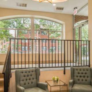 A cozy waiting area with armchairs and a small table, situated near large windows with a view.