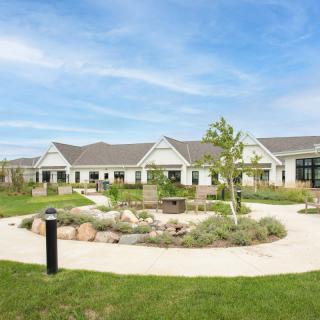 A picturesque building surrounded by a landscaped garden with pathways.