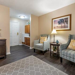 A cozy living area with two armchairs, a lamp, and wall art creating a welcoming atmosphere.