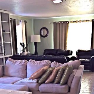 A cozy living room with sofas, pillows, and a lamp by the window.
