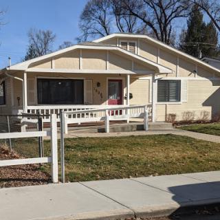 A charming single-story house with a welcoming porch and well-maintained front yard.