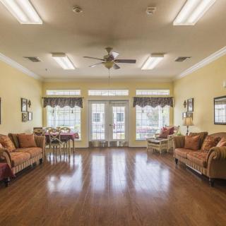 A spacious living room with comfortable couches, wooden flooring, and large windows letting in natural light.