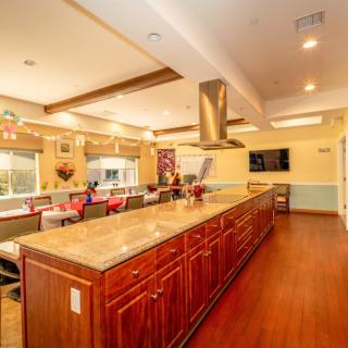 A spacious and modern kitchen with a large island, stainless steel appliances, and warm wood flooring.