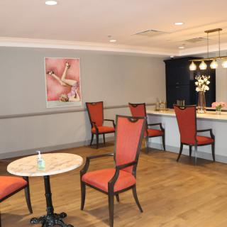 A cozy lounge area with red chairs and a small bar.