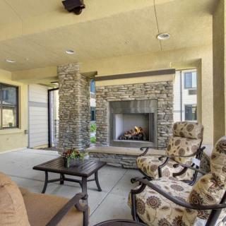 A cozy outdoor patio with a stone fireplace and comfortable seating.