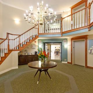Elegant foyer with a grand staircase and chandelier.