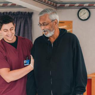 A healthcare professional assisting an elderly patient during rehabilitation.