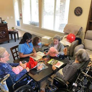 Residents engage in a group activity at a care facility, promoting social interaction and cognitive engagement.