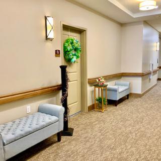 A well-lit and inviting hallway featuring plush benches and decorative elements.