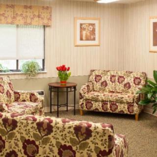 A cozy living room with floral-patterned seating and a small coffee table adorned with a plant.
