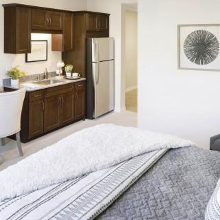 A modern studio apartment with a cozy bedroom area and compact kitchenette.