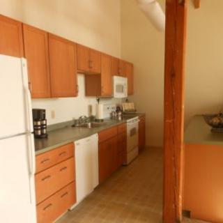 A kitchen with wooden cabinets, white appliances, and a countertop.