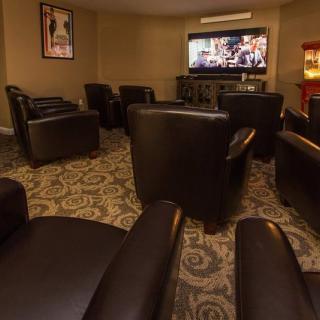 A cozy home theater setup with leather seating and a large TV screen.