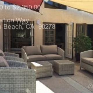A cozy outdoor patio setup with cushioned seating and an umbrella, perfect for relaxing.
