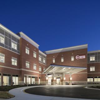 A well-lit hospital building at night, showcasing its modern architectural design.