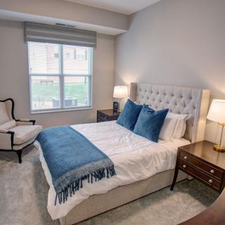 A cozy bedroom interior with a neatly made bed and elegant decor.