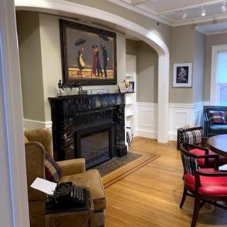 A cozy living room featuring a fireplace, surrounded by elegant artwork and furniture.