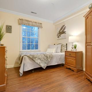 A cozy bedroom with wooden furniture and a bed next to a window.