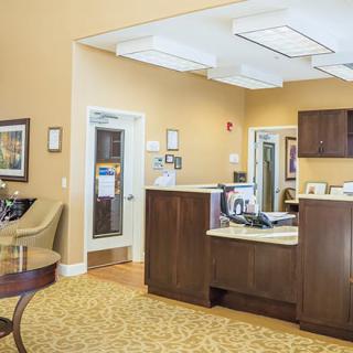 A modern reception area with a desk, seating, and warm lighting.