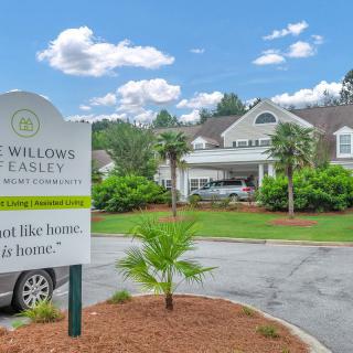 The front entrance of Willows of Easley, an assisted living community, featuring well-maintained landscaping and signage.