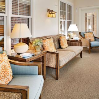 A cozy living room with comfortable seating, decorative cushions, and warm lighting.