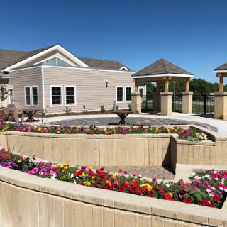 A beautifully landscaped area featuring a modern building and vibrant flower beds.