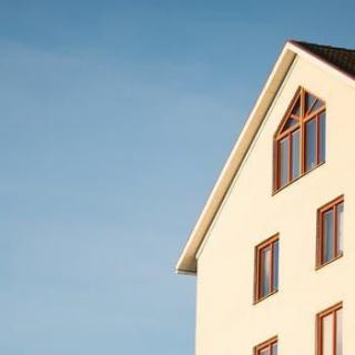 A minimalist view of a house against a clear blue sky.