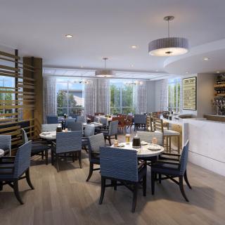 A modern restaurant interior with neatly arranged tables and a bar area.