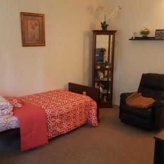 A cozy bedroom with a single bed and armchair.