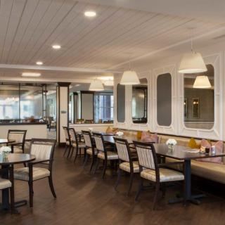 A modern restaurant interior with neatly arranged tables and chairs.