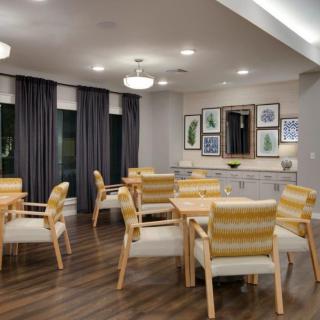 A modern dining area with neatly arranged tables and chairs, featuring soft lighting and elegant decor.