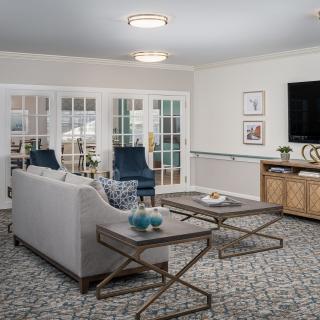 A modern living room with stylish furniture and decor, featuring a sofa, coffee tables, and a television.