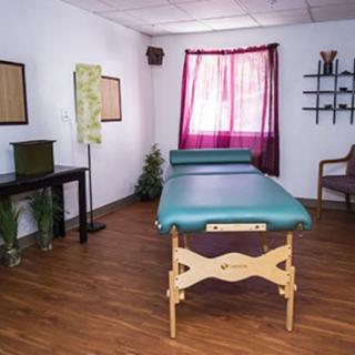 A tranquil massage room featuring a massage table and cozy decor.