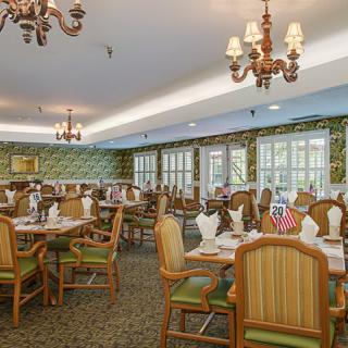 A classic and elegant dining room with ornate chandeliers and neatly arranged tables.