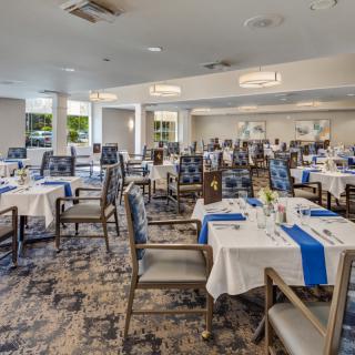 Elegant dining room set up with neatly arranged tables and chairs.
