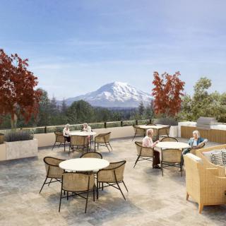 A scenic outdoor patio with tables and chairs, offering a stunning mountain view on a sunny autumn day.