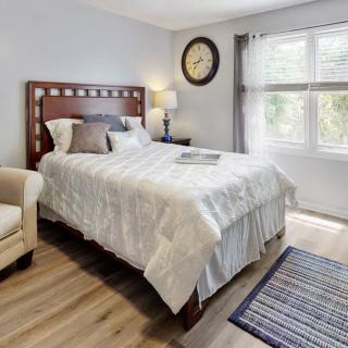 A cozy bedroom with a comfortable bed, a large window, and modern decor.