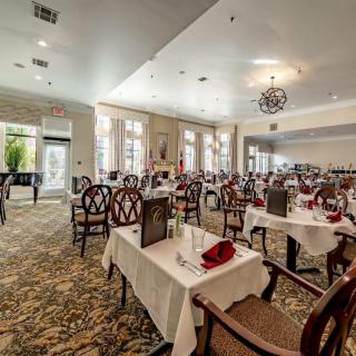 An elegantly set dining area in a restaurant with neatly arranged tables and chairs.