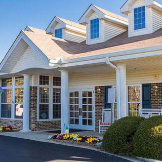 A suburban house with a porch and multiple windows.