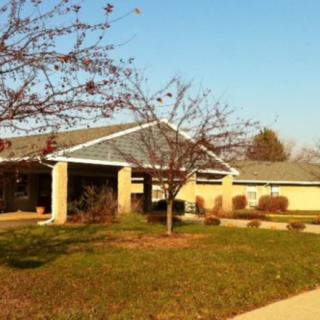 A small clinic building surrounded by trees on a clear day.