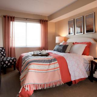 A cozy, modern bedroom with colorful bedding and elegant decor.