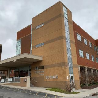 A modern hospital building with a brick exterior and multiple floors.