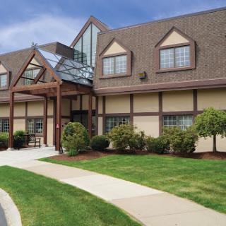 A modern building with a welcoming entrance and landscaped surroundings.