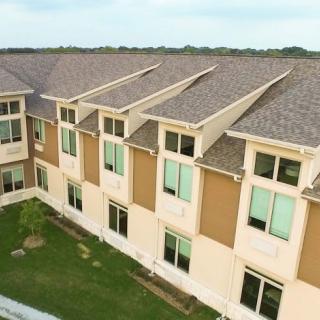 Aerial view of a modern residential building with multiple windows and sloped roofs.