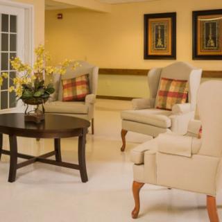 A cozy living room with armchairs, a wooden coffee table, and decorative elements.