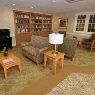 A cozy living room with comfortable seating, a bookshelf, and warm lighting.